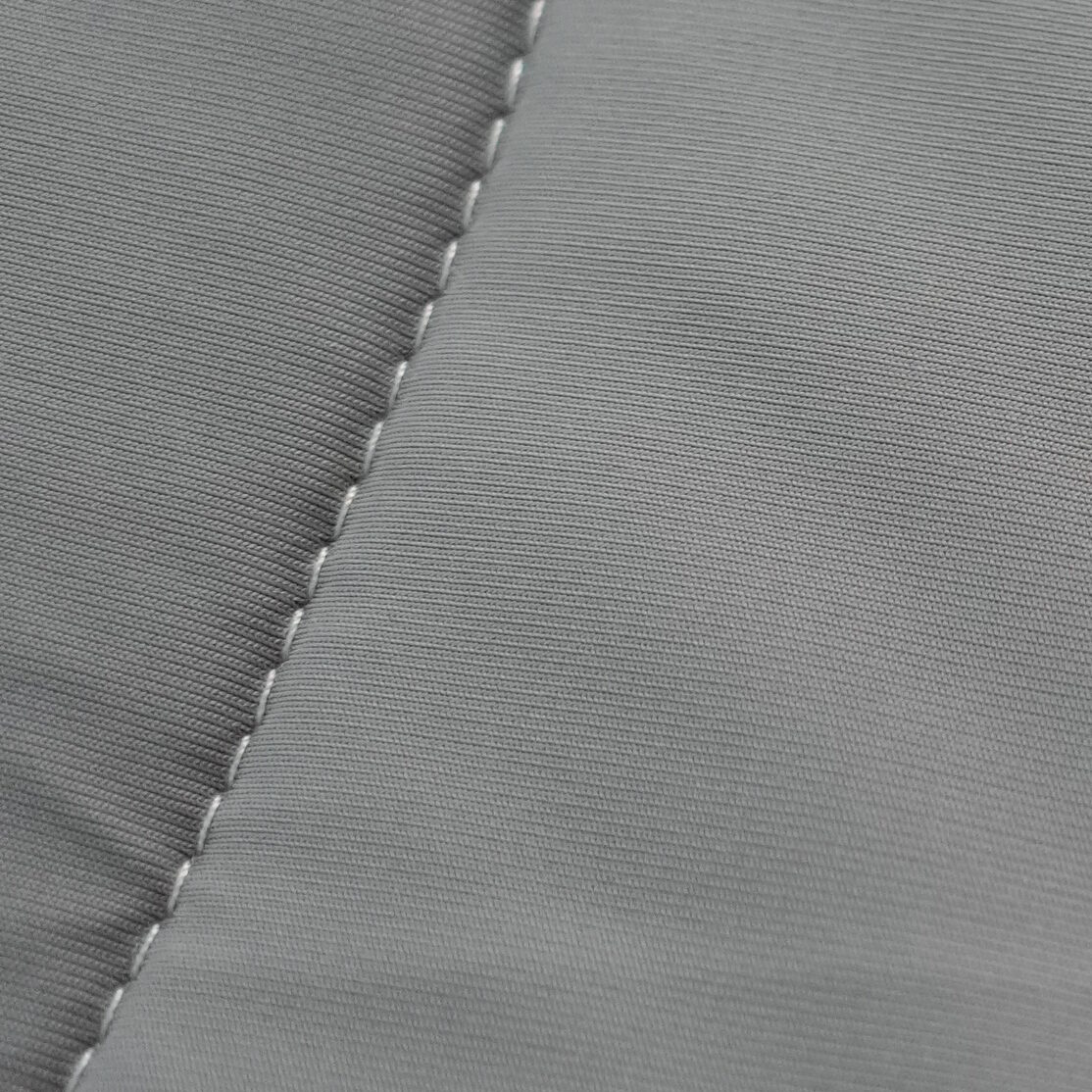Macro close-up of REST Evercool nylon bedding showing a tight, smooth, ribbed weave